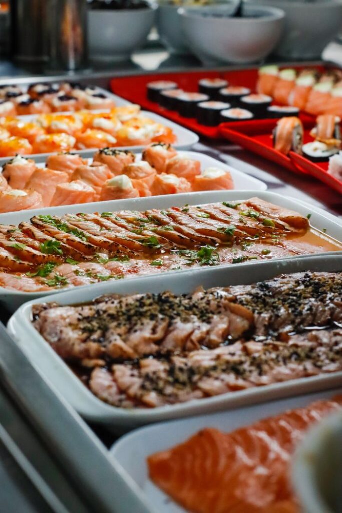 Variety of sushi and sashimi on trays, highlighting fresh seafood arrangement.
