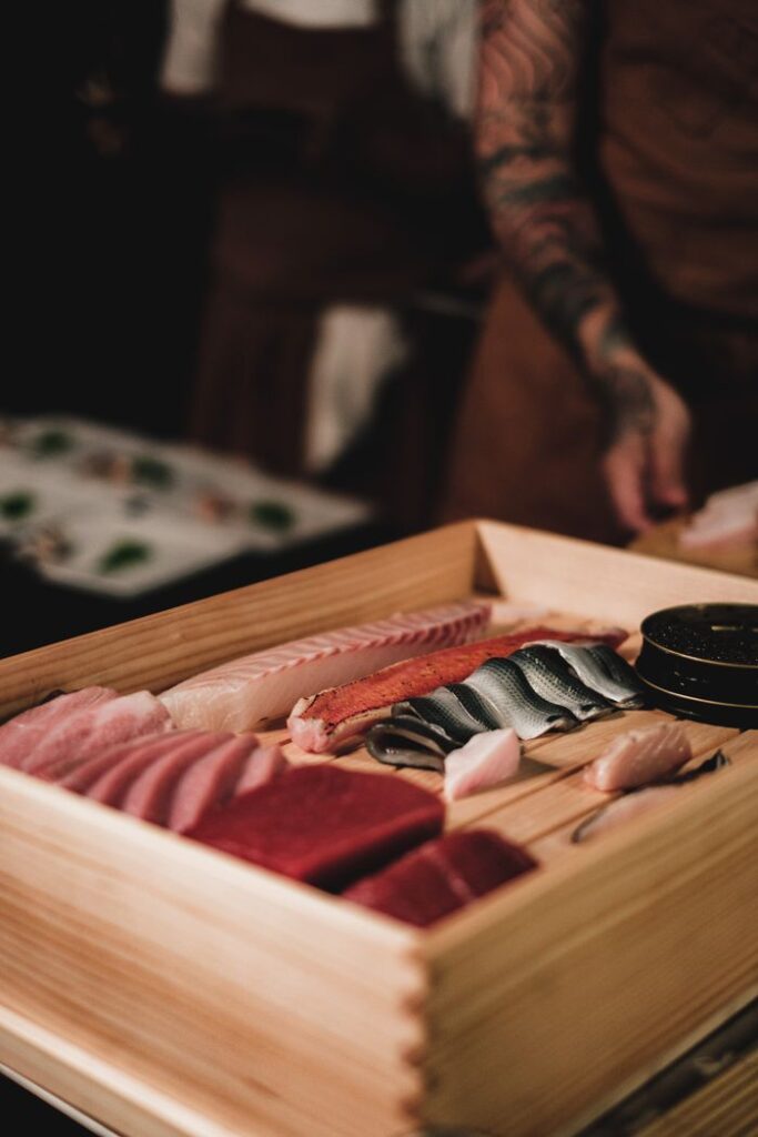 Close-up of an assorted sushi selection on a wooden tray, showcasing fresh sashimi and seafood.